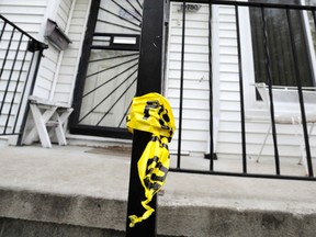 Police tape is wrapped around the railing outside a home Wednesday morning, May 11, 2016, in Detroit, where Police say a young girl fatally shot herself after finding a handgun under her grandmother's pillow. (Todd McInturf/Detroit News via AP)