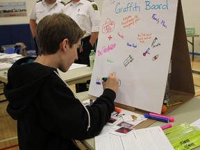 Joey McRae draws a backpack on the Huron County Health Unit’s “Graffiti Board.” Students were asked to draw something they would need in case of emergency. (Laura Broadley/Goderich Signal Star)
