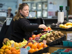 Angela Nadalin sorts through a basket of apples while shopping for fresh produce at The Doris Family Produce stand in the Covent Garden Market in London, Ont. on Wednesday May 11, 2016. (CRAIG GLOVER, The London Free Press)