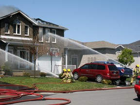 Emergency services battle a blaze at 1447 and 1449 Hanover Dr. in Kingston, Ont. on Wednesday May 11, 2016. Steph Crosier/Kingston Whig-Standard/Postmedia Network