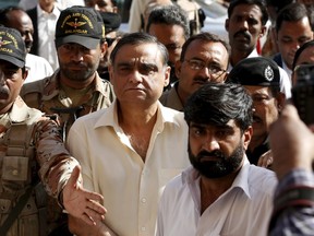 Police and Rangers soldiers escort Asim Hussain (C) into Sindh High Court in Karachi, Pakistan November 26, 2015. A Pakistani court ordered the prominent opposition politician close to former president Asif Ali Zardari into police custody on Thursday on charges of aiding terrorists in a case his party has called politically motivated. Hussain, a petroleum minister in the former Pakistan People's Party-led government, is accused of harbouring and providing medical treatment to militants and criminals at his hospital in the port city of Karachi.  REUTERS/Akhtar Soomro