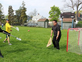 Queen Elizabeth II student Tatianna Robbins takes a shot at Aamjiwnaang First Nation Chief Chris Plain in net during a lacrosse game at Sarnia Collegiate Institute & Technical School (SCITS) Thursday. About 200 students participated in an annual aboriginal student symposium held at SCITS Thursday to learn more about aboriginal cultural activities, like lacrosse and teepee construction. (Barbara Simpson, The Observer)