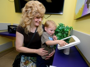 Bayfield?s Sandy Wallace and son Ashton, 3, try out an iPad in the new Smilezone at Children?s Hospital in London. (MORRIS LAMONT, The London Free Press)