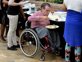 Gord Bartlett goes through the food line during a graduation ceremony Thursday for the Adaptive Cooking Class held at the Best Western Lamplighter Inn. Bartlett was one of the student chefs who helped prepare the lunch.  (MORRIS LAMONT, The London Free Press)