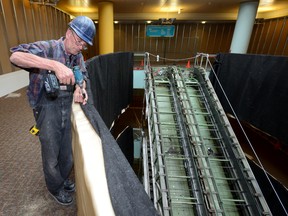 Supervisor Malcolm Pigott works Thursday near the Central Library?s escalator, which will be replaced with a stairway. A design rendering of the stairs, minus furnishings and colour choices, is shown at right. (MORRIS LAMONT, The London Free Press)