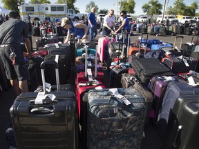 Baggage sits in the special events parking lot, Thursday, May 12, 2016, at Phoenix Sky Harbor International Airport. More than 3,000 checked bags missed their outbound flights in Phoenix because of a problem with a screening system at Sky Harbor International Airport, officials with Transportation Security Administration said. (Mark Henle/The Republic via AP)