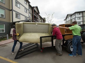 Volunteers Steve Gray, Bryan Wall and Clay Sappenfield help gather and distribute household items earlier this week in Airdrie, Alta. One group had gathered 35 truckloads of items to help settle 50 families in apartments that were made available rent-free for two months for Fort McMurray fire evacuees. (Britton Ledingham/Postmedia News )