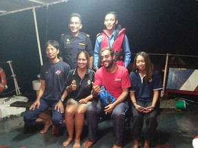 In this Thursday, May 12, 2016 photo released by the Malaysian Maritime Enforcement Agency, from front left to right, Lam Wai Yin, Marta Miguel, David Hernandez and Armella Ali Hassan pose for a photograph after being rescued at a resort in Sabah, Malaysia. The four were rescued after their boat capsized off the northern coast of the island of Borneo, the Malaysian coast guard said Thursday. (The Malaysian Maritime Enforcement Agency via AP)