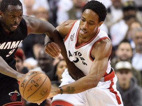 Toronto Raptors' DeMar DeRozan and Miami Heat's Luol Deng battle for a loose ball during first half NBA playoff action at the Air Canada Centre in Toronto on May 11, 2016. (THE CANADIAN PRESS/Frank Gunn)