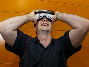 Sports reporter Gerry Moddejonge checks out Mike Reilly's simulation on a virtual reality headset at the Esks Quarterback Club at Commonwelath Stadium in Edmonton, Alta., on Thursday May 12, 2016. Photo by Ian Kucerak