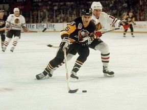 Penguins' Kevin Stevens (left) slips past the Blackhawks' Rod Buskas during the Stanley Cup final in Chicago on June 1, 1992. Stevens, a two-time Stanley Cup champion, has been charged in U.S. federal court with conspiring to sell oxycodone in Massachusetts. (Fred Jewell/AP Photo/Files)