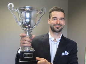 Warren WhiteKnight, a lawyer with Bergeron Clifford in Kingston, holds the trophy he shared following last year's third-place finish in an international soccer tournament for members of the legal profession. He will also be part of this year's team, representing Eastern Ontario, at the 2016 event in Spain. (Michael Lea The Whig-Standard)