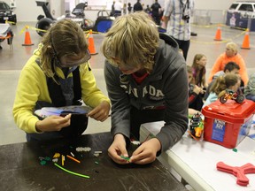 Katelyn Flannagan and Landon Monette from St. Jude's Catholic School in Ingersoll, try to put together a simple shape while wearing goggles that simulate the symptoms of being impaired by drugs or alcohol. The test, part of a presentation by MADD at the Racing Against Drugs program, is meant to mimic the fine motor skills a driver would use when pulling out their licence to show police. (MEGAN STACEY, Sentinel-Review)