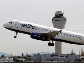 In this April 23, 2013, file photo, a JetBlue plane takes off in view of the air traffic control tower at Seattle-Tacoma International Airport, in Seattle. (AP Photo/Elaine Thompson, File)