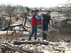 Canadian Prime Minister Justin Trudeau and and Fort McMurray Fire Chief Darby Allen (R) visit neighborhoods devastated by the wildfire that forced the evacuation of the city in Fort McMurray, Alberta, Canada May 13, 2016.  REUTERS/Jason Franson/Pool
