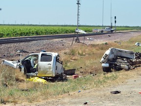 A pickup truck lies in pieces next to the train tracks after it was hit by an Amtrak train travelling westbound Friday, May 13, 2016, in Madera, Calif. A few men in a pickup truck died when the driver pulled in front of a speeding Amtrak passenger train, splitting the truck in two but causing no serious injuries to the train's passengers, authorities said. (Silvia Flores/The Fresno Bee via AP)