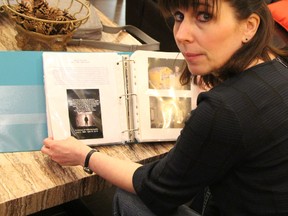 Janice Martell, who spearheaded the McIntyre Powder Project studying the effects of aluminum dust on gold and uranium miners, is seen here back in May 2016, leafing through a memorial album that was created as part of the McIntyre Powder Intake Clinic held in Timmins. The album has photos and information about miners who died from medical conditions suspected to have been caused by their repeated exposure to aluminum dust.