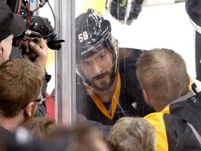 Pittsburgh Penguins' Kris Letang is seen through the glass as he is checked by a trainer during the first period of Game 1 of the NHL Eastern Conference finals against the Tampa Bay Lightning in Pittsburgh on May 13, 2016. (AP Photo/Gene J. Puskar)