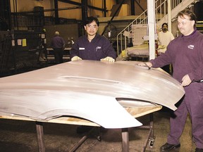 Ronnell Santos, left, and Trent Maki, general manager at Amino North America Corp. check the finish on a hood for a Saturn Sky produced at the St. Thomas factory in this file photo.