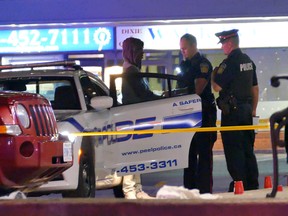 Officers at the scene where a man was shot to death in a parking lot in front of a Brampton bar on Friday night. Peel regional Police homicide detectives are investigating. PASCAL MARCHAND PHOTO