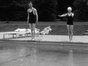 This undated handout photo provided by HM The Queen shows the then Princess Elizabeth swimming with her father, King George VI in Britain. Rare footage of Britain's Queen Elizabeth has been shared to celebrate her 90th birthday. (HM The Queen via AP)