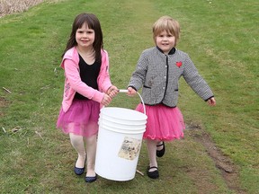 Veronica May, 5, left, and her sister, Alice, 4, carry a bucket filled with brook trout as they get ready to release the fish into Junction Creek at Twin Forks Playground as part of the Junction Creek Stewardship Committee's Junction Creek Festival in Sudbury, Ont. on Saturday May 14, 2016. John Lappa/Sudbury Star/Postmedia Network