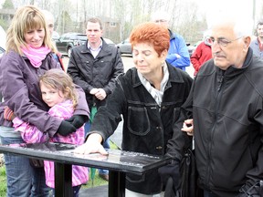 Franca Belli, mother of late former Ward 8 Councillor Fabio Belli, touches her son's image on a plaque at Twin Forks community garden in New Sudbury, alongside Fabio's father Gianfranco, wife Susan and daughter Brianna. Belli's daughter Emma and several of his friends and former colleagues on city council were also on hand for the dedication of the community garden at Twin Forks Playground on Saturday morning. Ben Leeson/The Sudbury Star/Postmedia Network
