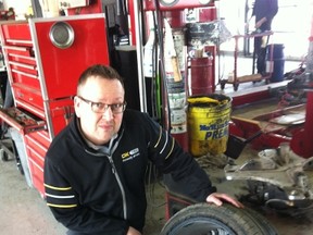 Chris Hudson, Owner/Manager of the OK Tire outlet on Regent Avenue West in Winnipeg, examines a tire damaged by a pothole on May 14, 2016, (GLEN DAWKINS/Winnipeg Sun/Postmedia Network)