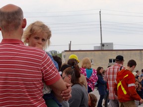 Three-year-old Florence Taylor waits in line with Dad, William Taylor, to take a high ride in a hydro-line bucket at the City of Kingston Public Works open house on Saturday morning. Steph Crosier, Kingston Whig-Standard, Postmedia Network