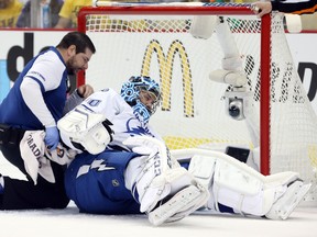 Tampa Bay Lightning head trainer Tom Mulligan (left) tends to goalie Ben Bishop after he was hurt against the Pittsburgh Penguins during Game 1 of the Eastern Conference final Friday at the CONSOL Energy Center. (Charles LeClaire/USA TODAY Sports)