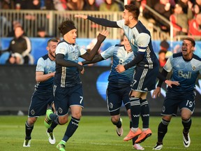 Vancouver Whitecaps midfielder Christian Bolanos (7) is greeted by team mates as they celebrate a goal against Toronto FC during Saturday night's game at BMO Field. (USA TODAY SPORTS)