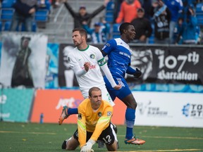 EDMONTON, AB. SEPTEMBER 27, 2015 - Lance Laing of FC Edmonton, runs behind keeper Kyle Zobeck of the New York Cosmos after Laing scored the first goal of the game at Clarke Stadium in Edmonton.