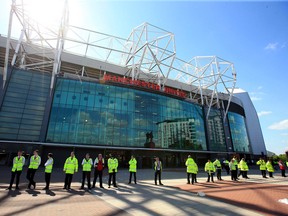 Security stewards stand outside Old Trafford stadium after today's final soccer match of the season between Manchester United and AFC Bournemouth was abandoned due to a suspect package being found inside the stadium. (Mike Egerton/PA via AP)