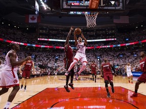 Toronto Raptors' guard Kyle Lowry drives past Miami Heat forward Luol Deng during second half round two NBA basketball playoff action in Toronto on Sunday, May 15, 2016. (THE CANADIAN PRESS/Nathan Denette)