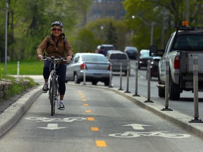 Sue-Ann Levy rides her bike in the designated bike lane on Queen's Park Circle in Toronto on Tuesday May 10, 2016. (Dave Abel/Toronto Sun)