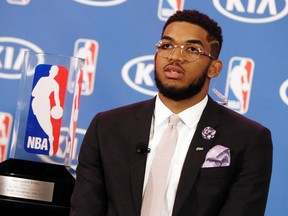 Minnesota Timberwolves' Karl-Anthony Towns sits by his trophy as he waits for another interview after the news conference announcing his selection as NBA basketball rookie of the year Monday, May 16, 2016, in Minneapolis.  (AP Photo/Jim Mone)