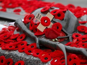A cross is surrounded by poppies placed on the Tomb of the Unknown Soldier following Remembrance Day ceremonies at the National War Memorial in Ottawa, Canada November 11, 2015. REUTERS/Chris Wattie
