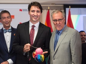 Prime Minister Justin Trudeau receives the 2016 Laurent McCutcheon Award for his commitment to fighting homophobia and transphobia from the hands of founder, Laurent McCutcheon during a ceremony in Montreal, Monday, May 16, 2016. THE CANADIAN PRESS/Paul Chiasson