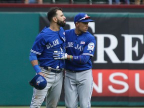 Toronto Blue Jays outfielder Jose Bautista (19) is held back by teammate Ryan Goins after a fight against the Texas Rangers in Arlington, Tex., Sunday, May 15, 2016. (AP Photo/LM Otero)