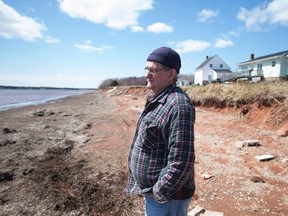 Dave Haley stands near his house along the shore in Lennox Island, P.E.I., on April 25, 2016. Rising sea levels and coastal erosion threaten the Mi'Kmaq community which has seen a major loss of landmass in the last 50 years. (THE CANADIAN PRESS/Andrew Vaughan)
