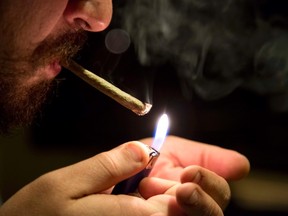 In this Oct. 29, 2013, file photo, a man smokes marijuana inside his apartment where he uses a hydroponics system to grow his weed. (AP Photo/Eduardo Verdugo, File)