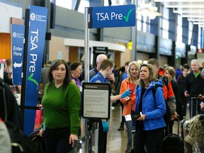 In this March 17, 2016, photo, travellers authorized to use the TSA PreCheck expedited security line at Seattle-Tacoma International Airport in Seattle have their documents checked by Transportation Security Administration workers. (AP Photo/Ted S. Warren)