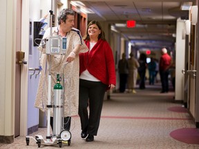 In this Sunday, Feb. 14, 2016, photo, Phil Sauvageau and his wife, Emily, walk down a hallway at Nebraska Medicine in Omaha, Neb. Phil credits God for his successful lung transplant. In late January, Phil Sauvageau was the first recipient of a lung transplant since 1998 at Nebraska Medicine. (Ryan Soderlin/Omaha World-Herald via AP)