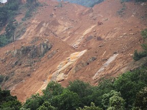 This photograph provided by Sri Lankan Red Cross shows scene after a massive landslide at Aranayaka in Kegalle District, about 72 kilometers (45 miles) north of Colombo, Sri Lanka, Wednesday, May 18, 2016. Massive landslides triggered by torrential rains crashed down onto three villages in the central hills of Sri Lanka, and several families were missing Wednesday and feared buried under the mud and debris, the Sri Lankan Red Cross said. (Sri Lanka Red Cross via AP)