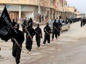 This undated file image posted on a militant website on Tuesday, Jan. 14, 2014, which has been verified and is consistent with other AP reporting, shows fighters from the al-Qaida linked Islamic State of Iraq and the Levant (ISIL), now called the Islamic State group, marching in Raqqa, Syria. An online image released Wednesday, Aug. 12, 2015,  purported to show the Islamic State affiliate in Egypt had beheaded a Croatian hostage. (AP Photo/Militant Website, File)