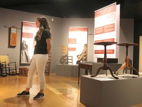 Amanda Di Sabatino, a summer student at the MacLachlan Woodworking Museum in Kingston looks over a new exhibit dedicated to the Shakers, a religious group that made a unique style of furniture. (Michael Lea/The Whig-Standard)