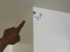 A Rexdale man points to where the bullet ricocheted off the kitchen ceiling and struck two walls before ending up on the floor of his living room. CHRIS DOUCETTE/TORONTO SUN