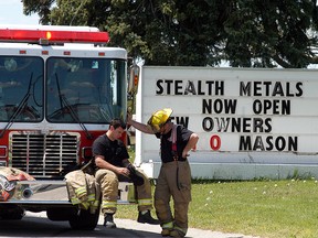 Chatham-Kent firefighters take a break after fighting a fire at Wallaceburg's Stealth Metal Recyling and Processing on May 18.