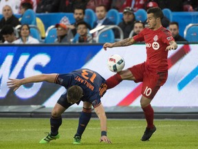 Toronto FC forward Sebastian Giovinco (10) battles for a ball with New York City FC defender Frederic Brillant during the second half at BMO Field on Wednesday night. The game ended in a 1-1 draw. (USA TODAY)