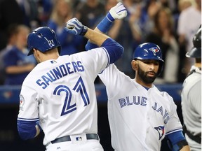 Blue Jays' Michael Saunders is congratulated by teammate Jose Bautista after he hit a home run during fifth inning against the Tampa Bay Rays on Wednesday night at the Rogers Centre. (The Canadian Press)